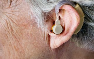 Closeup of senior adult womans ear with hearing aid